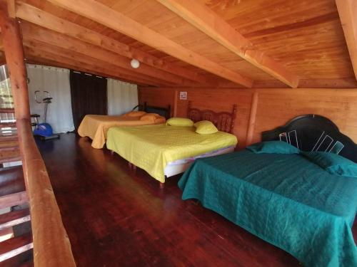 a bedroom with two beds in a wooden cabin at Finca pedacito de cielo in Paraíso