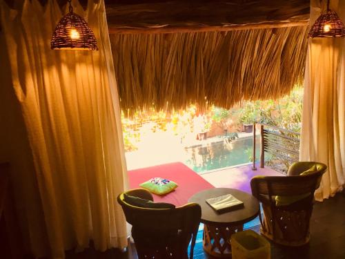 uma sala de jantar com uma mesa e cadeiras e uma janela em Hacienda La Rusa em Barra de Potosi