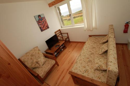 a living room with a couch and a chair at Casa Branca do Porto in Cinco Ribeiras