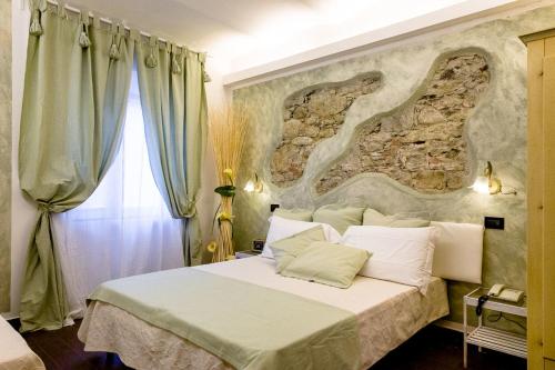 a bedroom with a large bed with a stone wall at Hotel Marina in Monterosso al Mare