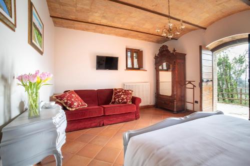 a living room with a red couch and a tv at Domus Antiqua Bed & Breakfast in Spello