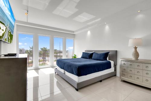 Un dormitorio blanco con una cama azul y una ventana en Perfect condo, room for everyone! Beachfront resort en South Padre Island