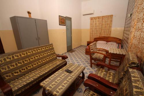 a room with two benches and a table and chairs at Amy's Hotel in Lomé