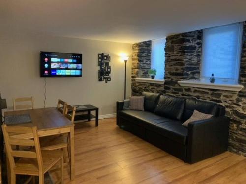 a living room with a black couch and a table at Cozy 1-bedroom in Bauer Terrace next to Citadel in Halifax