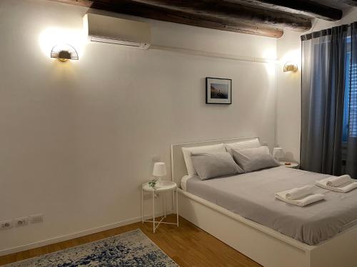 ein weißes Schlafzimmer mit einem Bett und einem Fenster in der Unterkunft Tortona, 12 - Tra Fashion e Design in Mailand