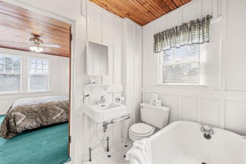 a bathroom with a toilet and a sink and a bed at Junaluska Lodge in Lake Junaluska