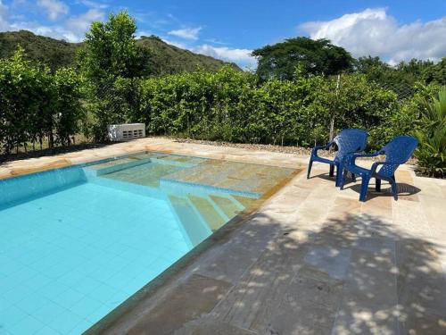 two chairs sitting next to a swimming pool at Casa de Recreo - Vacation House in Honda