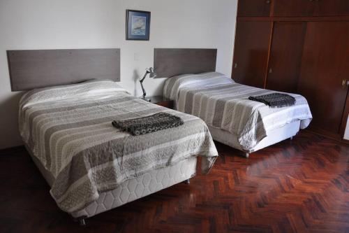 two beds in a room with wooden floors at Los Olivos de Cayma in Cayma