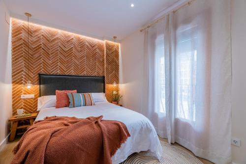 a bedroom with a large bed and a large window at Vestal Suites Domo in Cambrils