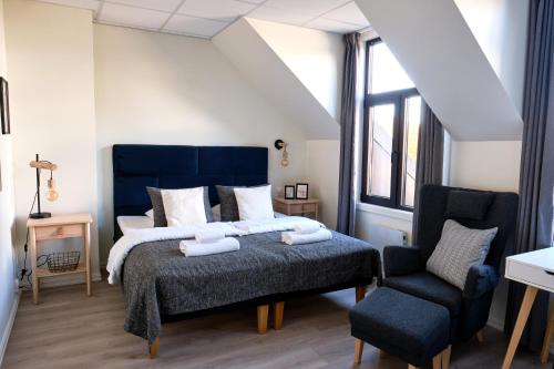 a bedroom with a king sized bed and a chair at Moss Hotel & Apartments in Moss