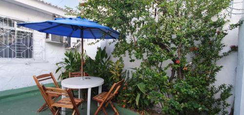 Casa do Meio Pousada في ريسيفي: طاولة وكراسي مع مظلة على الفناء