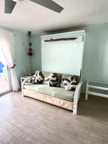 a couch with pillows on it in a room at Sunny Villa in the Marina - Excellent Water Views in Jolly Harbour