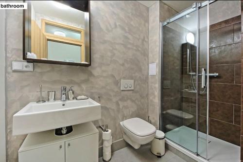 a bathroom with a sink and a toilet and a shower at Prague Style Condo 60m2 - 9 Min Walk Wenceslas Sq in Prague