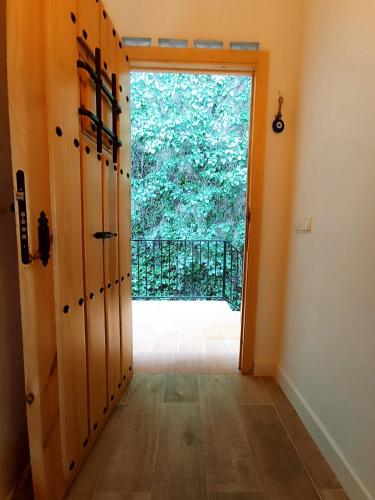 a hallway with a door leading into a room with a large window at APARTAMENTO AMANECER in Zahara de la Sierra