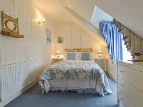 ポート・アイザックにあるEdgehillのベッドルーム1室(青と白のベッドカバー付)