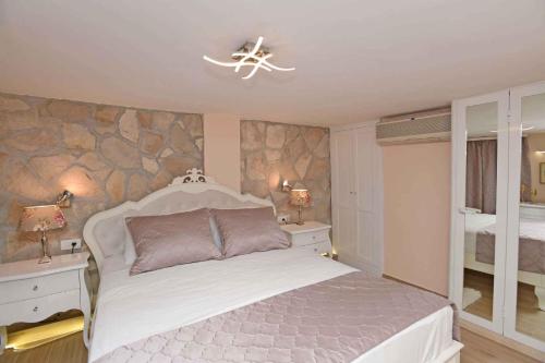 ein Schlafzimmer mit einem Bett und einer Steinmauer in der Unterkunft Holiday home in Dubrovnik 43524 in Dubrovnik