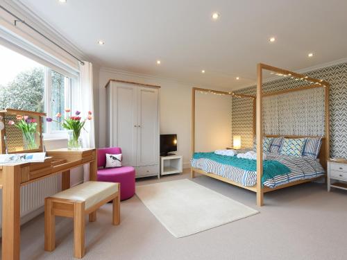 a bedroom with a canopy bed with a desk and a desk at Shamal in Carbis Bay