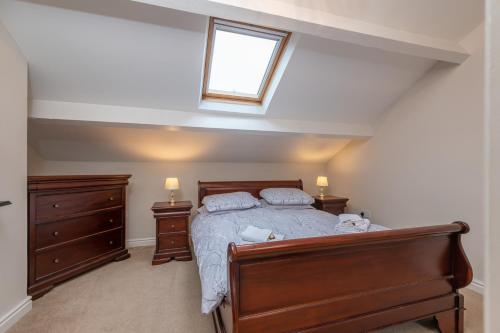 a bedroom with a bed and two dressers and a window at Sleeps 5 - 3 Bedrooms - walk to the square hosted Happy Valley cast in Hebden Bridge