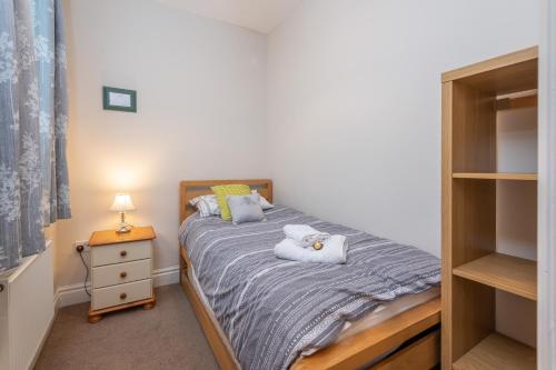 a small bedroom with a bed and a night stand at Sleeps 5 - 3 Bedrooms - walk to the square hosted Happy Valley cast in Hebden Bridge