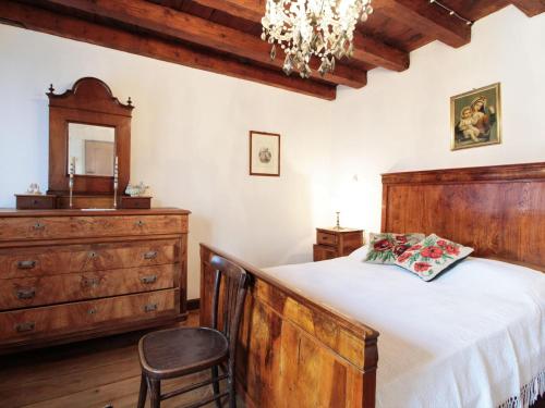 - une chambre avec un lit, une commode et un lustre dans l'établissement Beautiful holiday home in Chies d'Alpago with garden, à Chies dʼAlpago