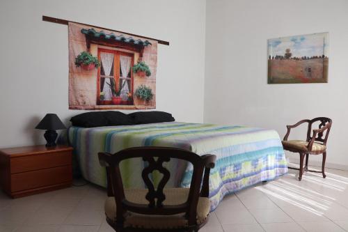 um quarto com uma cama, uma cadeira e uma janela em Appartamento in villa con vista Monviso em Piossasco