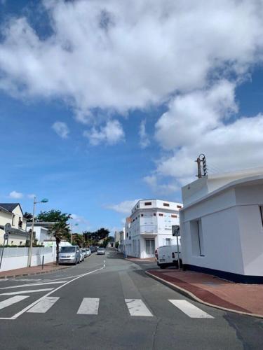 eine leere Straße mit Autos, die an der Seite eines Gebäudes geparkt sind in der Unterkunft L'Exotic - Saint Gilles Croix de Vie in Saint-Gilles-Croix-de-Vie