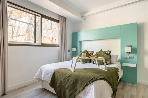 a bedroom with a bed with a blue wall at Playa del Pirata IKiGai in San Bartolomé