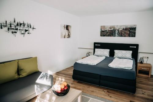 a living room with a bed and a couch at Waldpension Jägerstüberl in Bad Griesbach