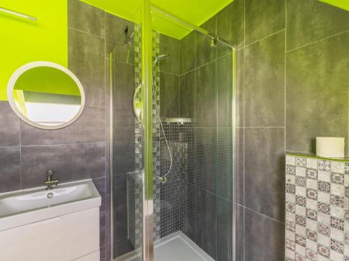 a bathroom with a shower with a sink and a mirror at Charming Cottage with Sauna in Audregnies