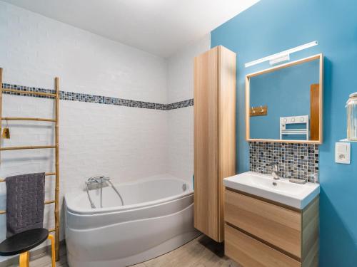 een badkamer met een wit bad en een wastafel bij Rural Holiday Home with Sauna in Honnelles 