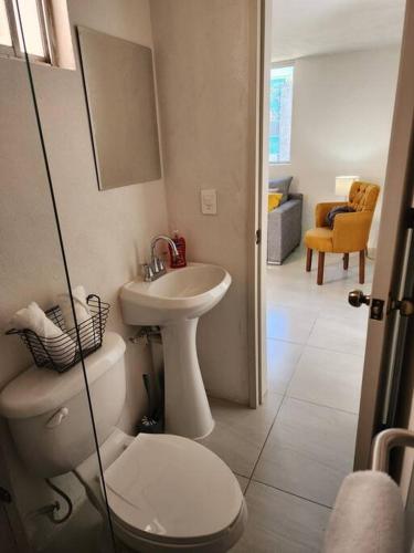 a bathroom with a white toilet and a sink at Práctico y cómodo caminando a la Expo Guadalajara in Guadalajara