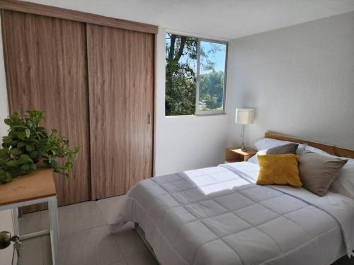 a bedroom with a large bed and a window at Práctico y cómodo caminando a la Expo Guadalajara in Guadalajara