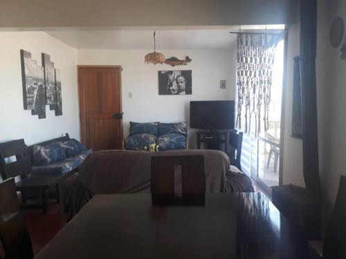 a living room with a couch and a television at Casa en Consistorial in El Tabo