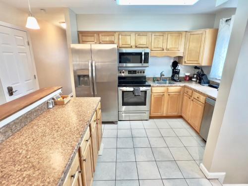 a kitchen with wooden cabinets and stainless steel appliances at Spacious Ranch Queen Beds 15 min Downtwn in Cincinnati