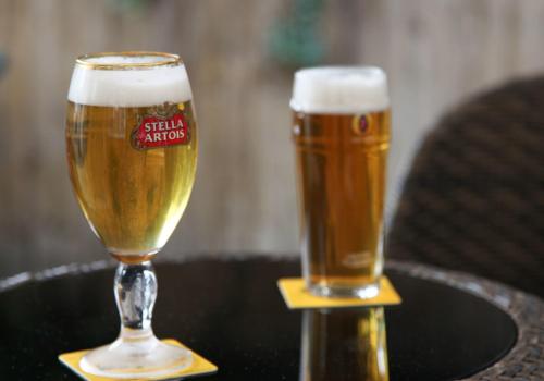 two glasses of beer sitting on a table at Heathrow Inn Hotel in Hillingdon