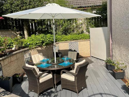 a table and chairs with an umbrella on a patio at The Apartment in Nairn
