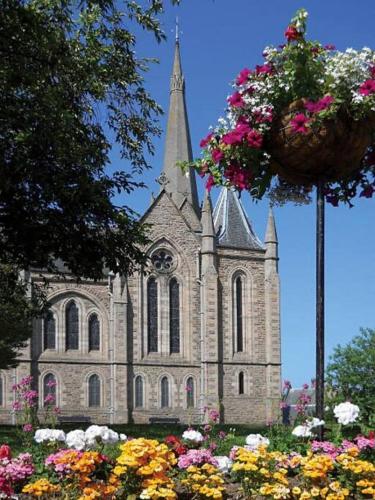 a church with a bunch of flowers in front of it at The Apartment in Nairn