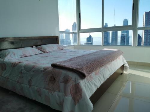 a bed in a bedroom with a large window at Lovely Apartment 2 BR in Panama City