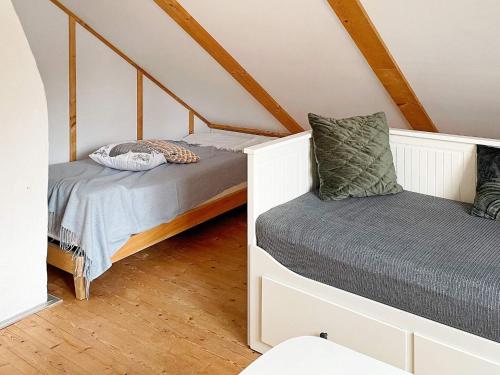 2 Betten in einem Dachzimmer mit Holzböden in der Unterkunft Holiday home FORSHEDA II in Forsheda