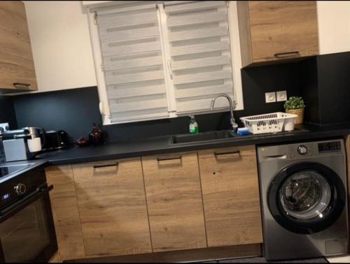 a kitchen with a washing machine and a window at Appartement Premium Le Marquis in Pfastatt