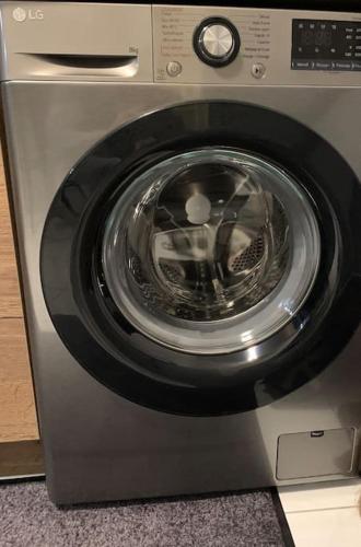 a washing machine with its door open on a floor at Appartement Premium Le Marquis in Pfastatt