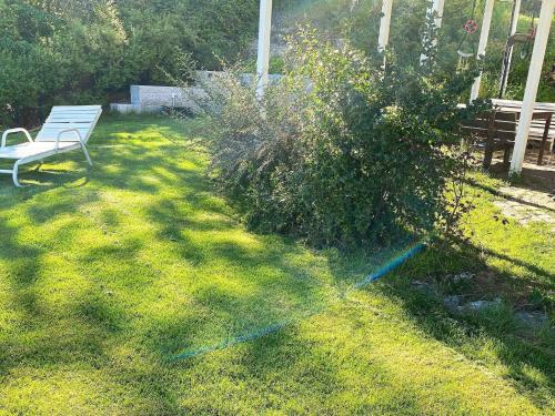 a garden with a white bench and a bush at 9 person holiday home in NESØYA-By Traum in Sandvika