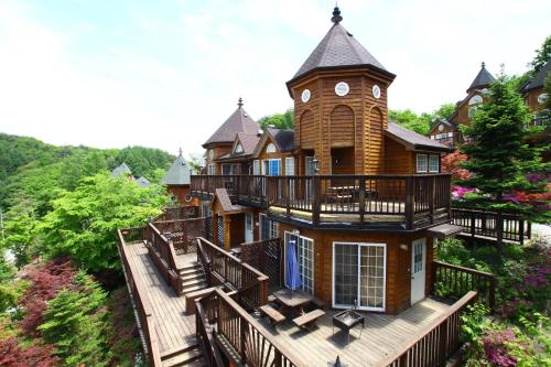 une grande maison avec une tour sur une terrasse dans l'établissement Korea Quality Elf Hotel, à Pyeongchang