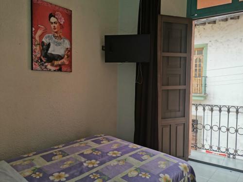 a bedroom with a bed and a picture on the wall at HOTEL LIMÓN in Xalapa