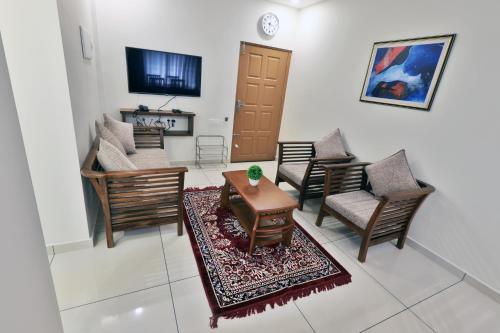 a living room with chairs and a table and a tv at Castle Brook Residential Homestay in Thiruvalla