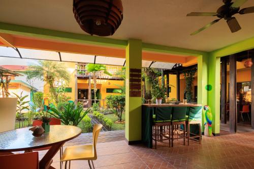 a restaurant with green walls and tables and chairs at Hotel Boutique La Casa de las Flores in Cahuita