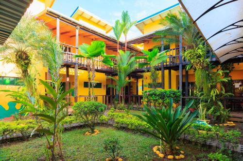 a courtyard of a building with trees and plants at Hotel Boutique La Casa de las Flores in Cahuita