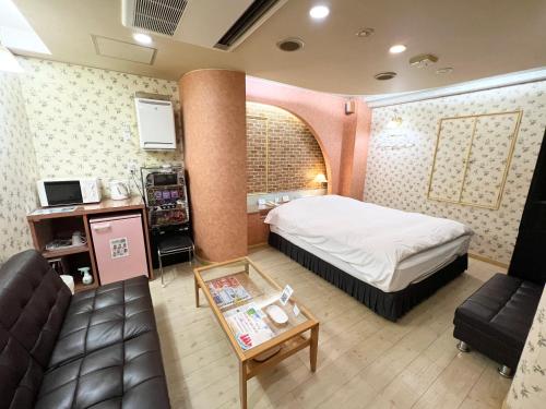 a hotel room with a bed and a couch at HOTEL MINT HOUSE -resort and relaxation- in Mihama