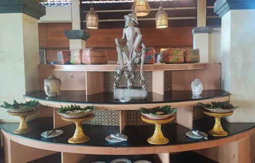 a shelf with vases and a statue on it at Inna Sindhu Beach Hotel & Resort in Sanur