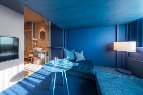 a blue room with a table and a bathroom at toggle hotel suidobashi TOKYO in Tokyo